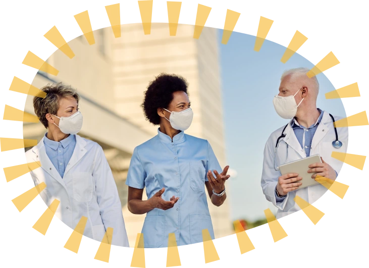 Health care providers speaking together outside a medical facility