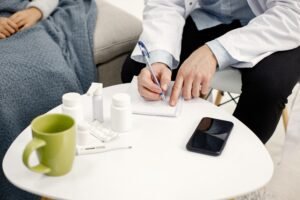 Doctor writing notes during a patient consultation about health care treatment and costs