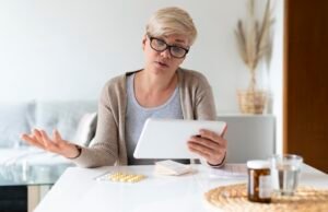 Woman reviewing health care costs and medical information on a tablet at home